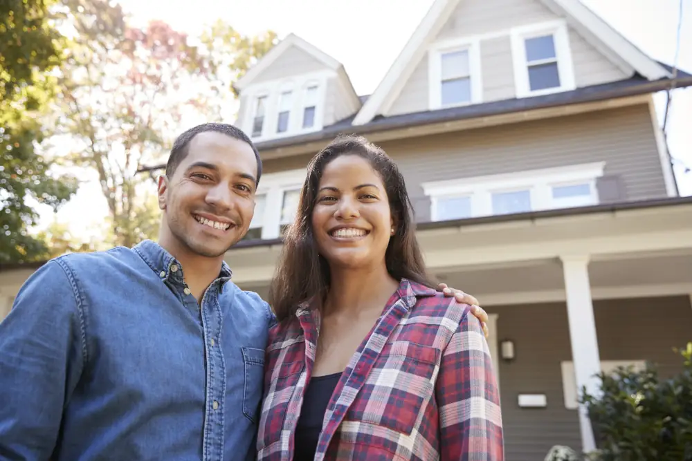 Common plumbing emergencies - Portrait Of Smiling Couple Standing In Front Of Their Home
