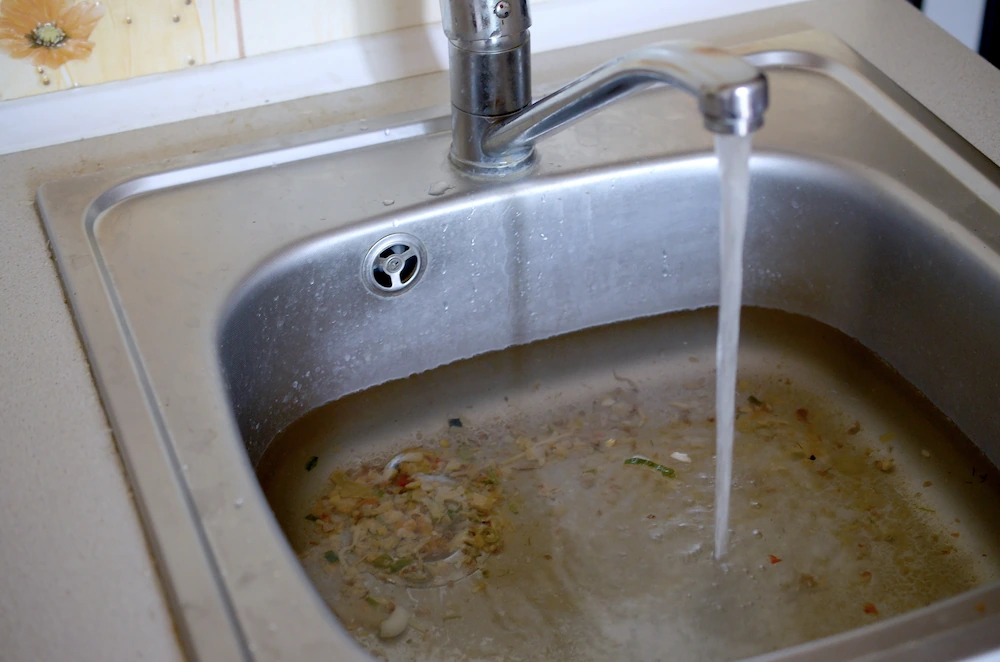stainless-steel-sink-plug-hole-close-up-full-of-water