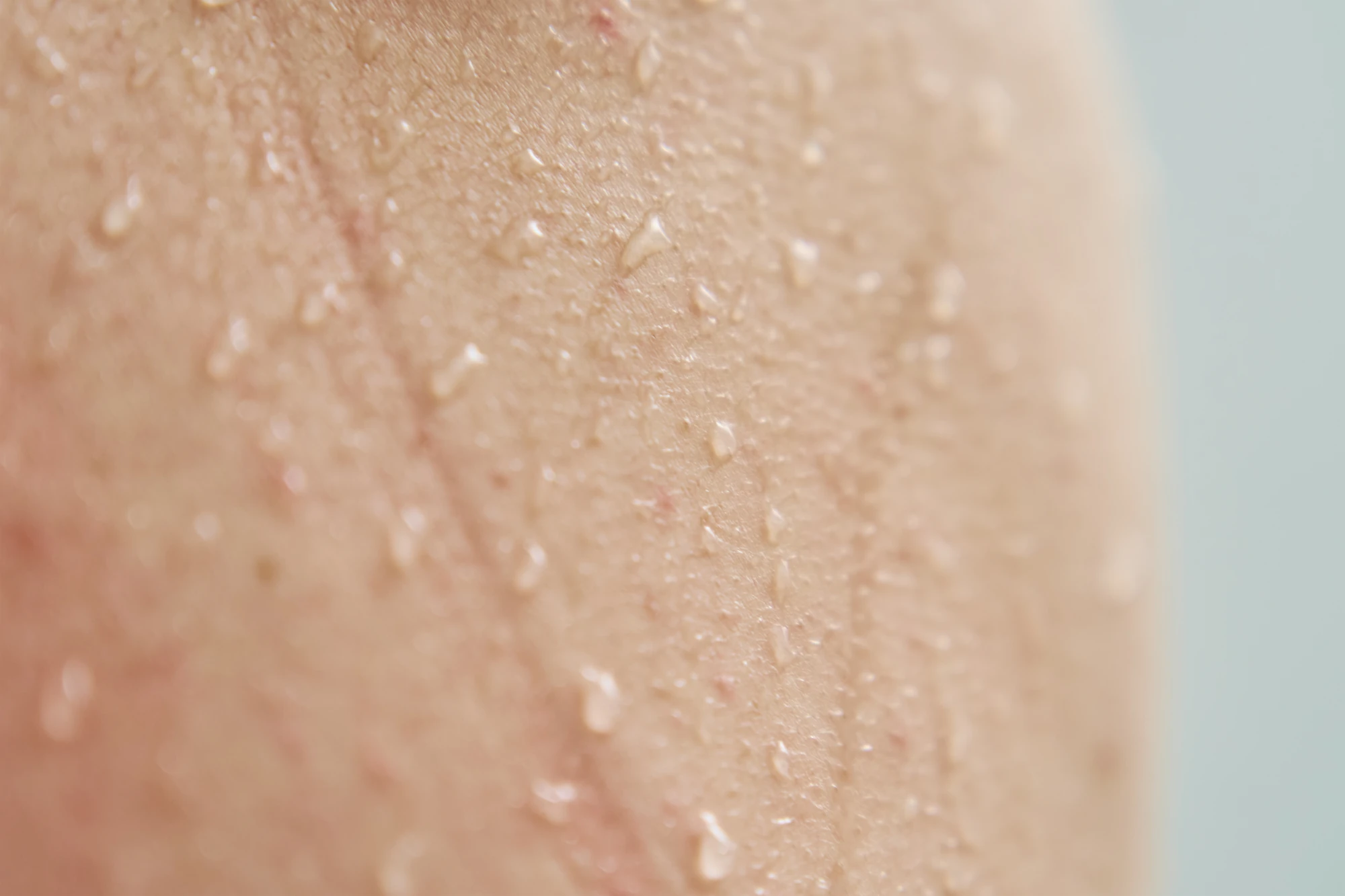 Female body skin with water drops in shower