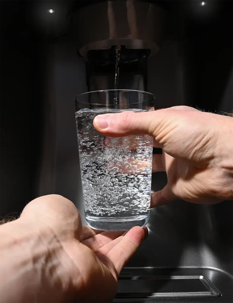 Hands pouring a glass of water