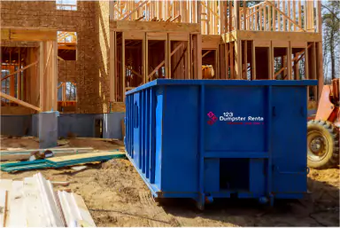 Blue dumpster rental at a residential construction site