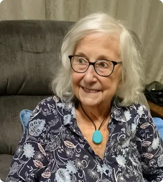 Elderly lady smiling with safety necklace on