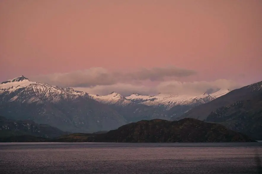 Lake Wanaka and the mountains at sunset under a pink sky