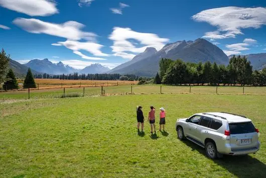 Guests beside a Private Discovery Tours vehicle on Earnslaw Station
