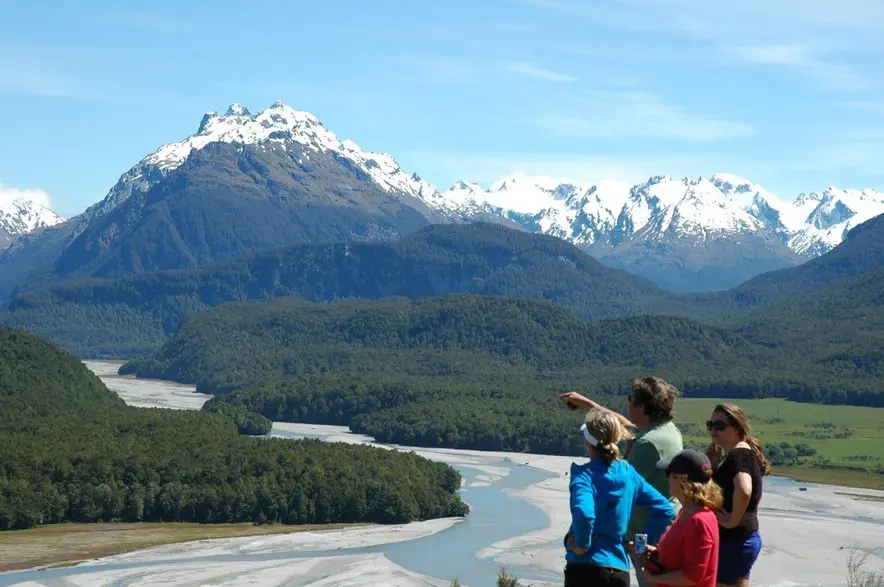 Tourists viewing snow-capped mountain valley
