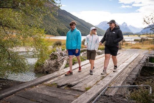 Guide and guests walking across a wooden bridge near Diamond Lake