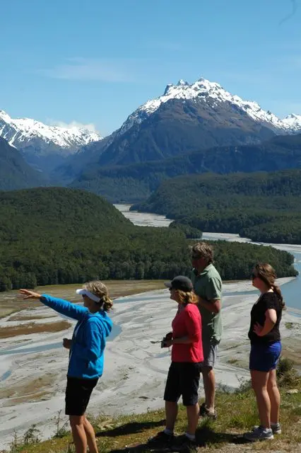 Group pointing at mountain river view