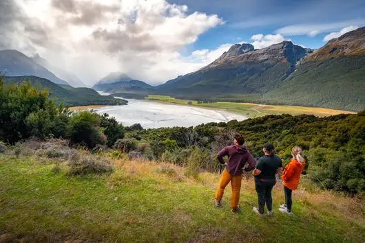 Guests at a viewpoint on the Mt Alfred Terraces walk, looking over a braided river valley
