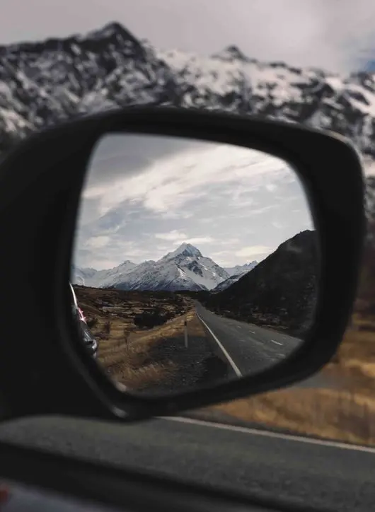 Aoraki Mount Cook reflected in a car wing mirror on the road into the national park