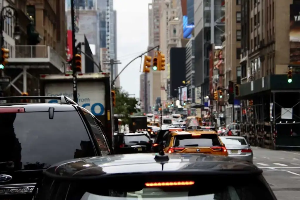 Dense urban traffic with taxis and delivery trucks stuck in a downtown bottleneck.