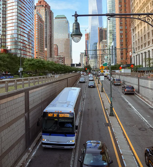 Transit bus marked not in service driving down a city street near a skyscraper.