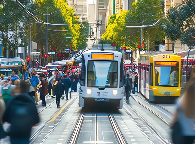 Modern trams travel through a busy urban corridor, representing the measurable transportation outcomes ALTRANS helps organizations achieve through TDM programs.
