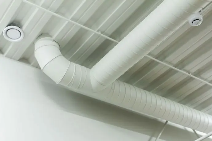 White spiral ventilation duct t-junction on ceiling for industrial hvac system website design