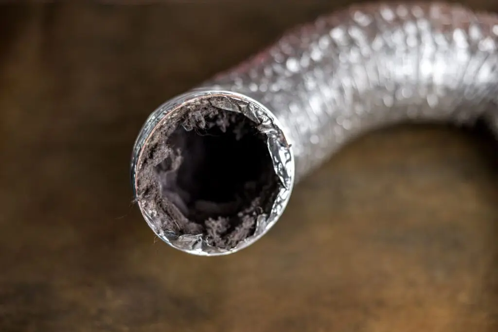 A dirty laundry flexible aluminum dryer vent duct ductwork filled with lint, dust and dirt
