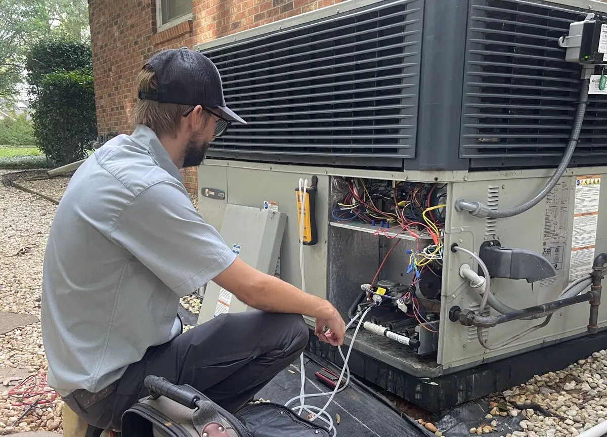 Panther HVAC team member maintaining a large AC unit