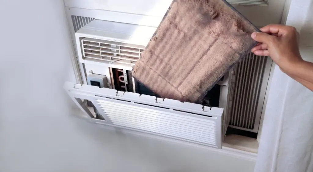 woman's Hand holding the dirty air conditioner home window filter