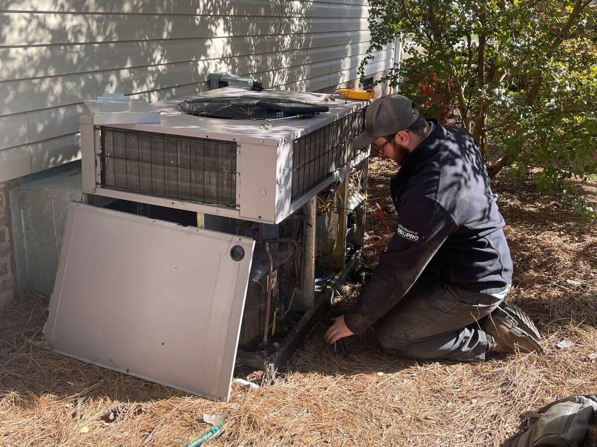 heat pump defrost cycle worker repairing ac unit