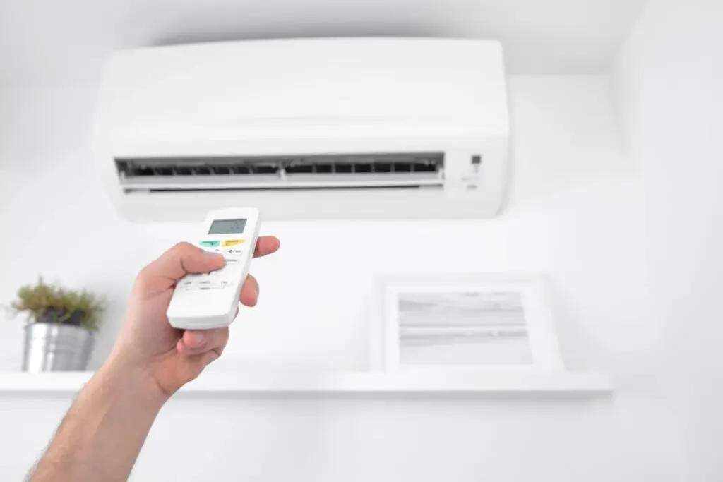 Man holding a modern AC unit remote
