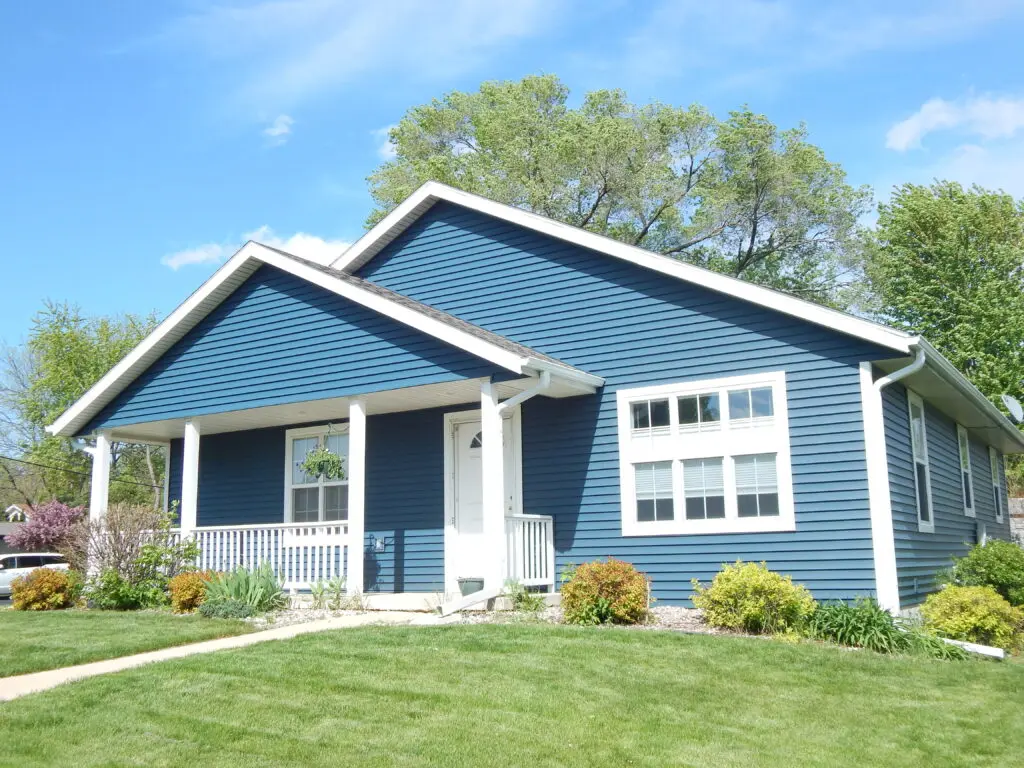 A single-story blue house with white trim 