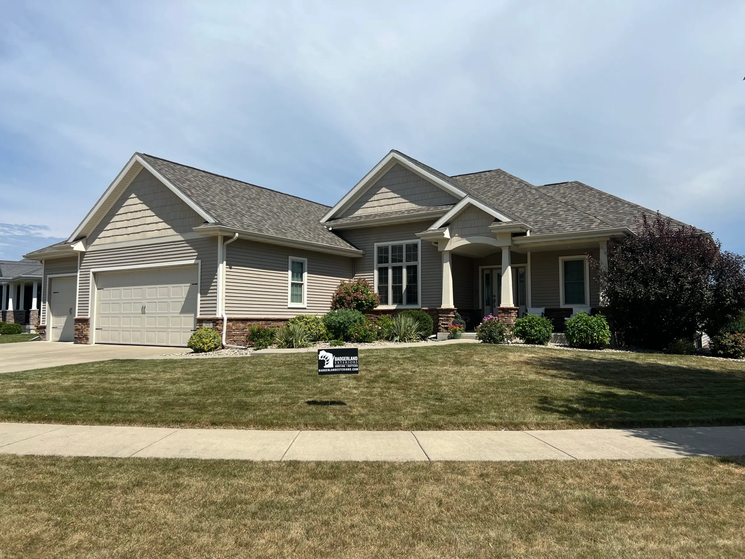 A big residential home with light grey asphalt shingle roof.