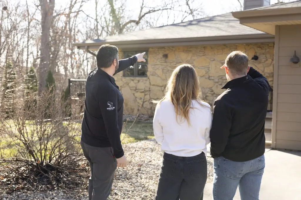 roof inspection wisconsin people standing in front of a small house