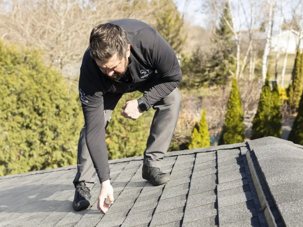 guy inspecting shingles