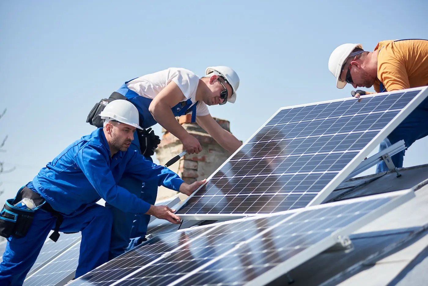 A group of men working on solar panels.