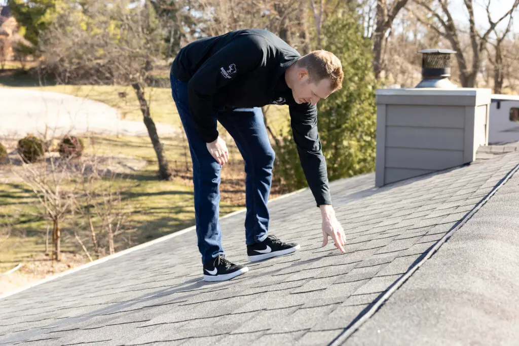 roof inspection services worker inspecting shingles