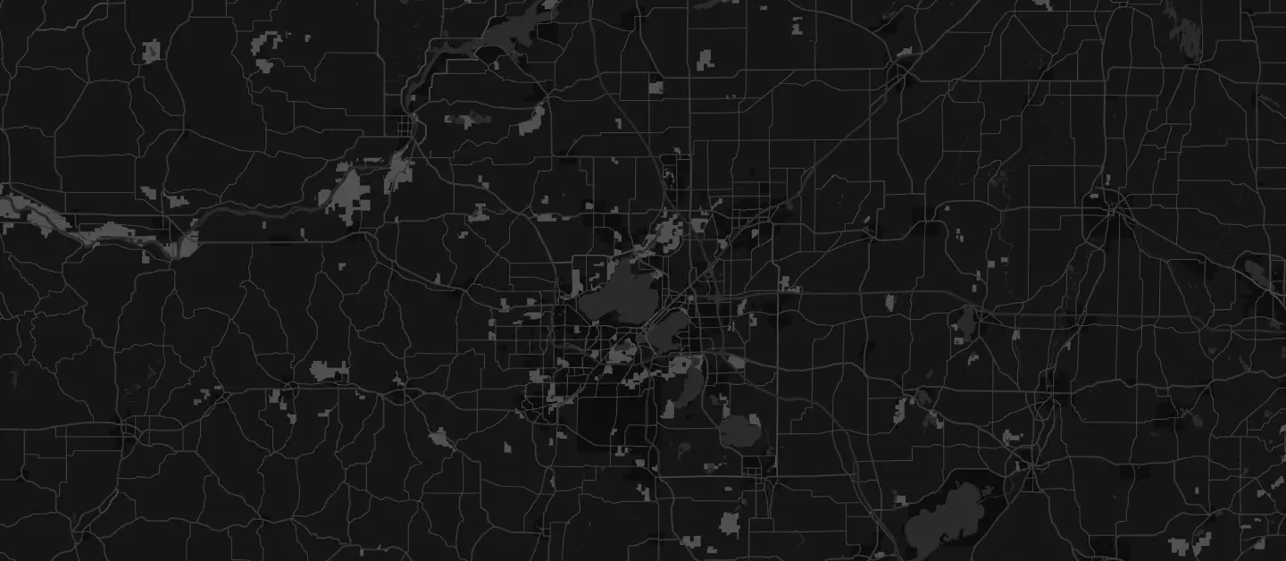 A dark-themed map displaying a network of roads and some water bodies. The map features intricate lines and shapes representing various geographic and urban areas.