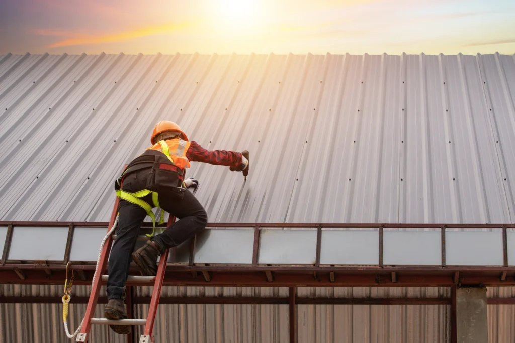 commercial roofing mcfarland worker installing metal roof with safety gear