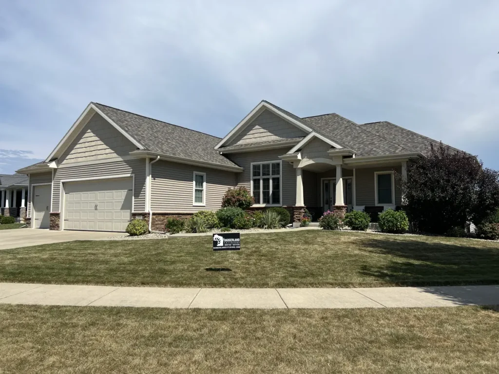 home in Verona, WI with a roof installed by Badgerland Exteriors. Badgerland sign is in the front yard.