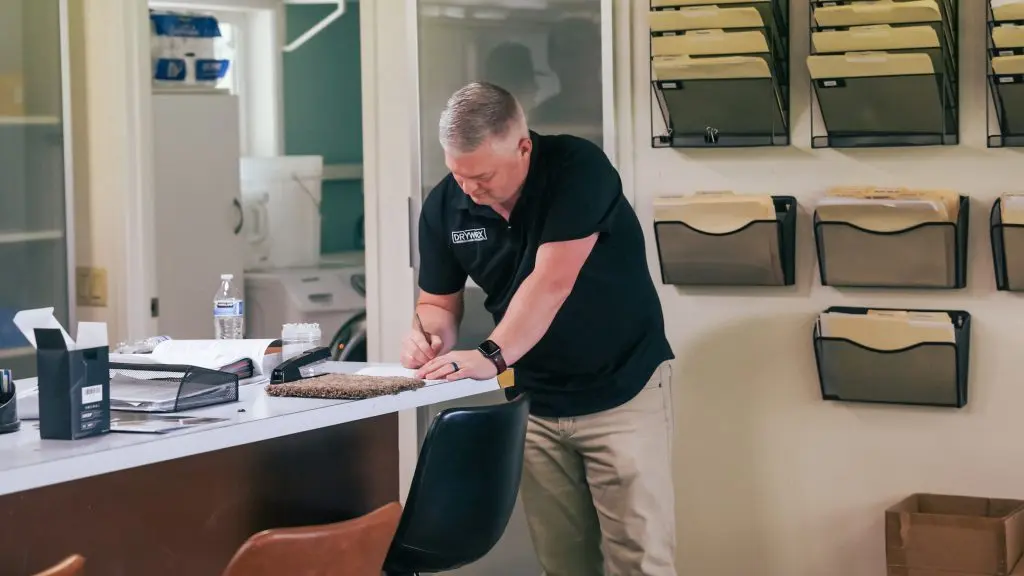 Water damage restoration technician inspecting flooded room in Vancouver WA