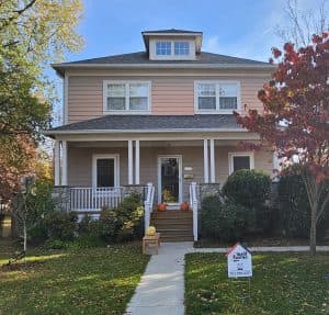 Beautiful multi-story house decorated for autumn with pumpkins on the steps. Bright, inviting exteri.