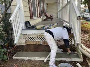 Renovation of front porch with new concrete steps and landscaping.