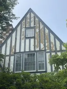 Historic Tudor house with weathered facade and prominent windows.