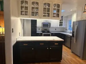 Stylish modern kitchen featuring black lower cabinets and white upper cabinets with glass doors.