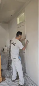Man painting a door in a home interior for renovation or decoration.
