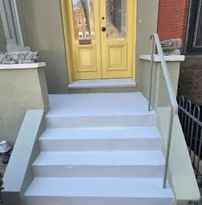 Newly painted front steps and yellow door of a residential building.