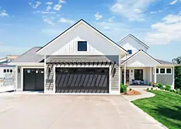 House exterior with garage, driveway, and landscaped yard in a suburban neighborhood.