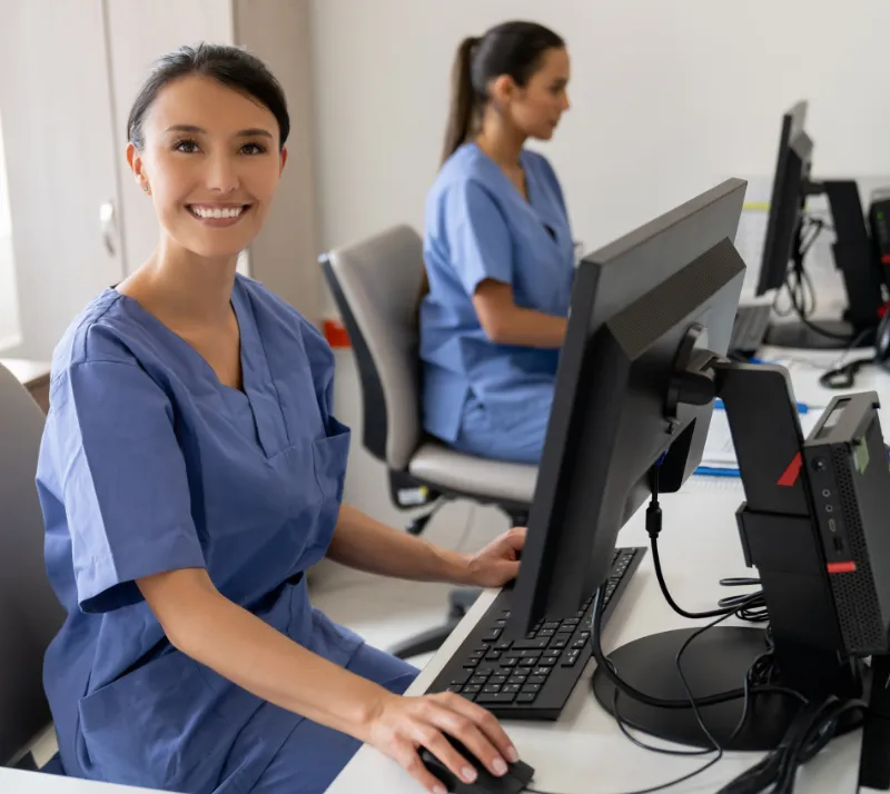 Smiling urgent care front desk employee at her workstation