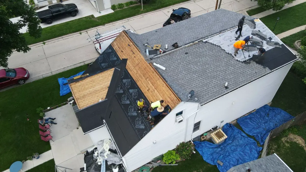Aerial view of a roof replacement in progress, First Fruits Construction team working