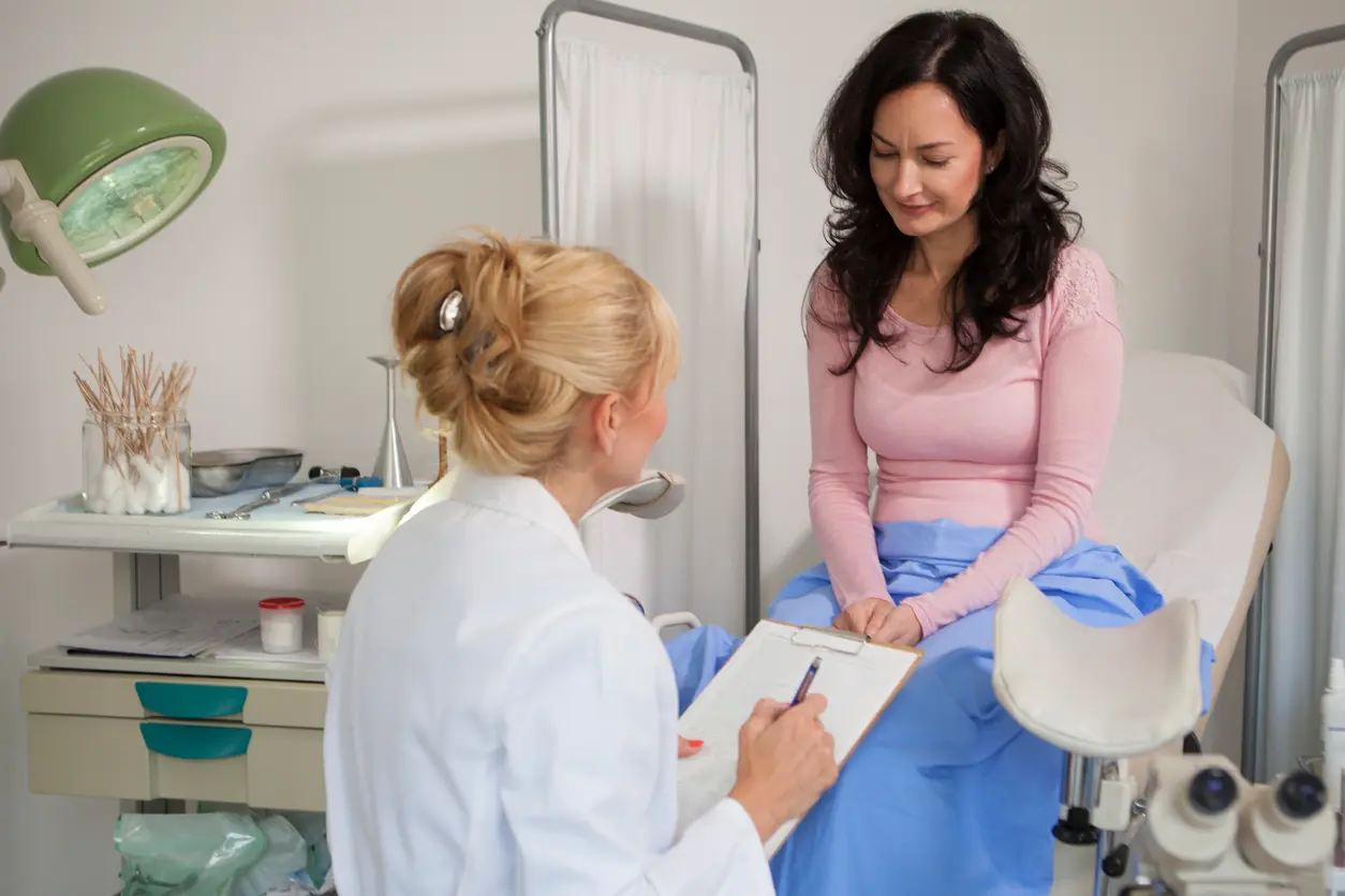 Gynaecologist examining a patient with a microscope