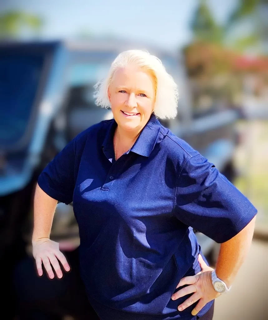 Brenda Moore, General Manager of Capital Improvement, smiling in a navy polo shirt, showcasing her customer-focused approach in a professional setting.