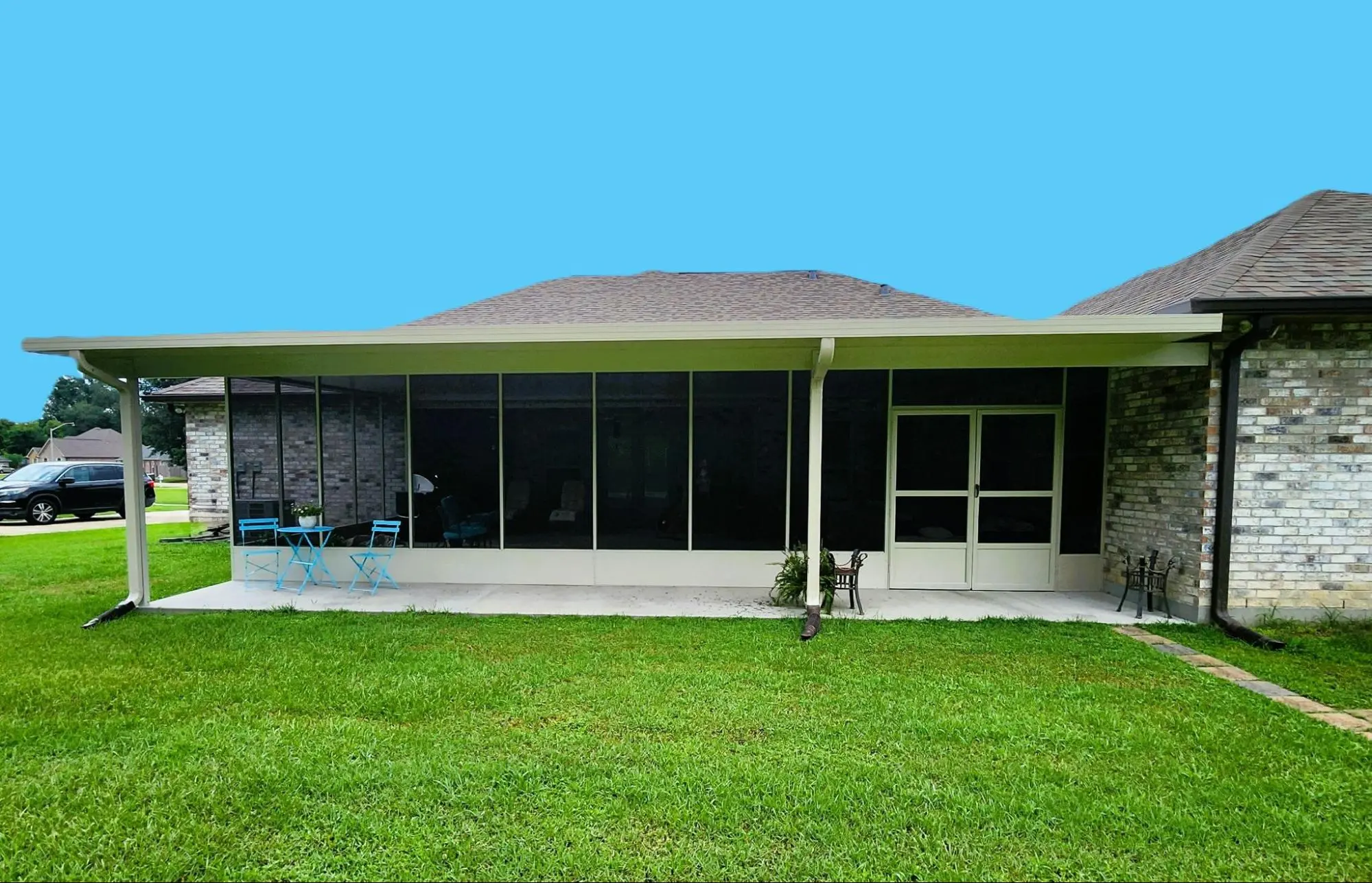 Insulated patio cover enhancing outdoor living space with blue chairs and table in Greater New Orleans.