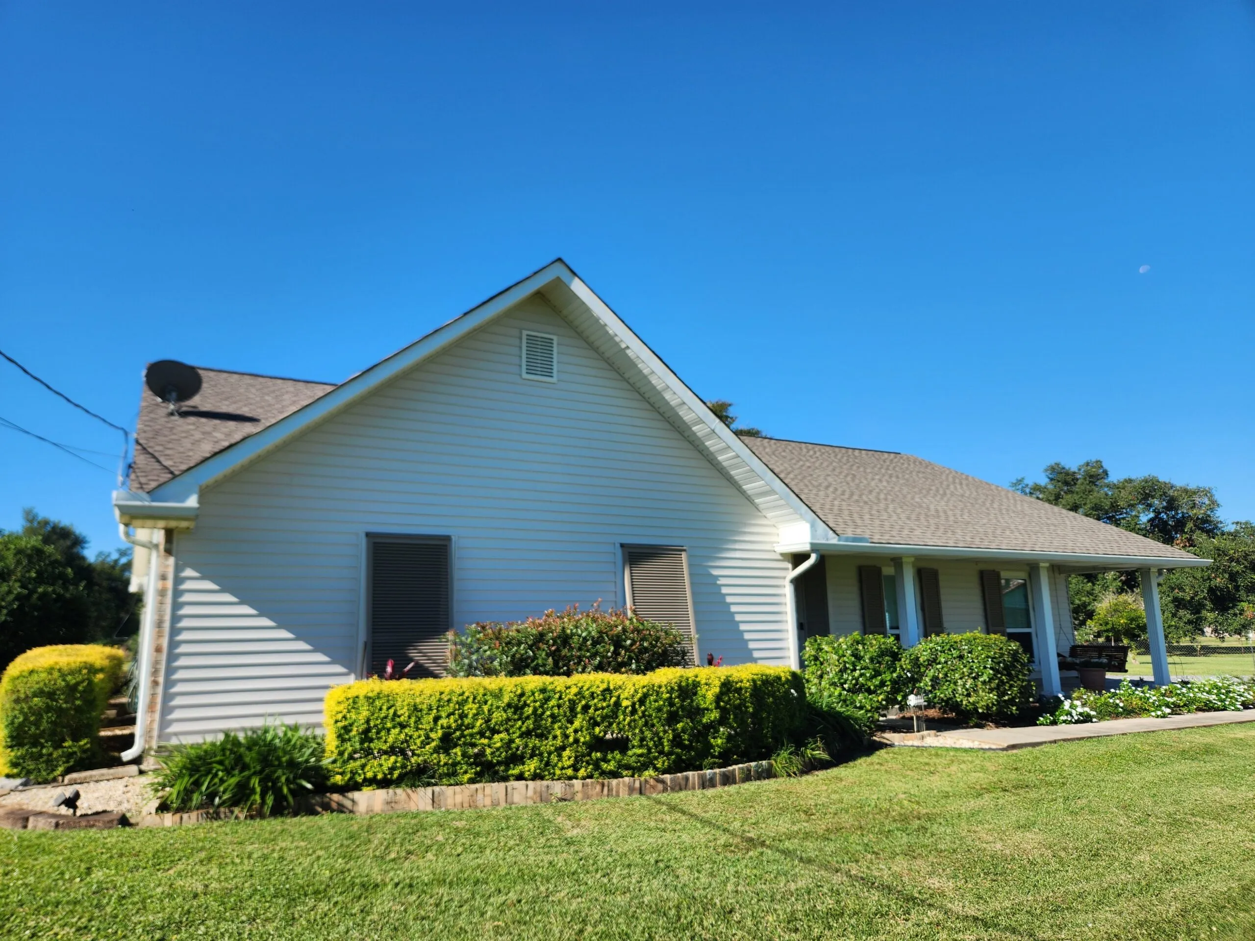 Siding project in Hahnville, LA, featuring newly installed ProVia 5" Traditional vinyl siding in Antique White, sleek white vinyl-coated aluminum fascia, and vinyl shutters, enhancing the home's exterior aesthetics and durability.