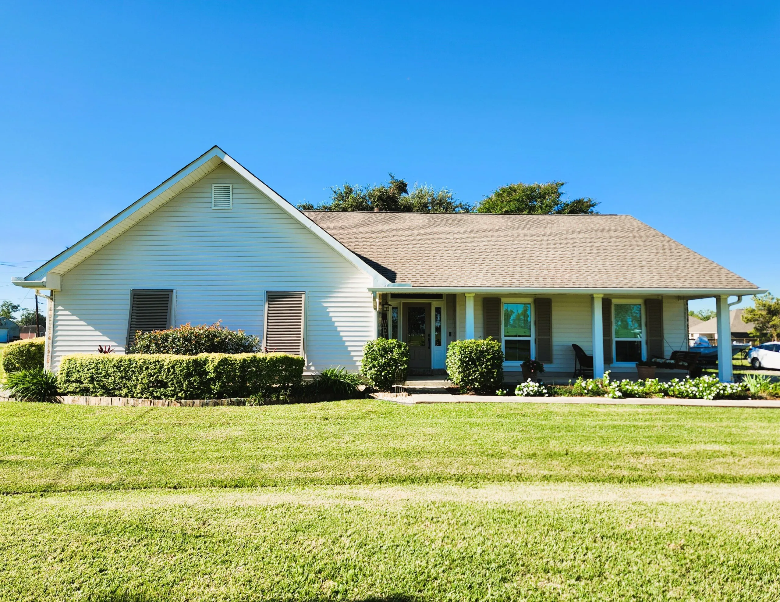Home exterior in Hahnville, Louisiana featuring newly installed ProVia 5&Prime; Traditional vinyl siding in Antique White, white vinyl-coated aluminum fascia, and vinyl shutters, showcasing a polished and durable facade.