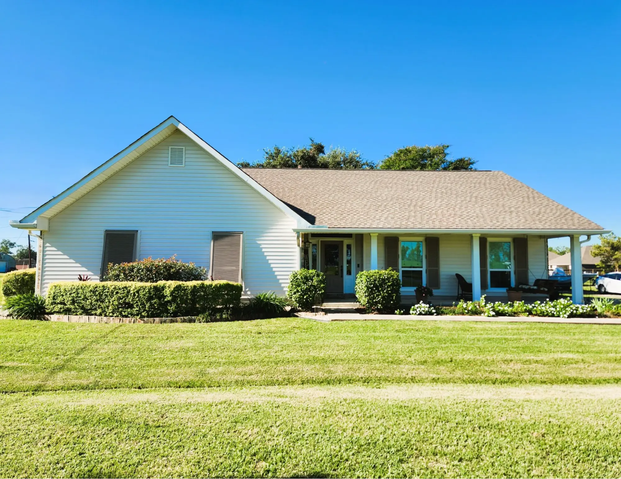 House featuring vinyl siding, well-manicured lawn, and porch, illustrating suitable siding options for Louisiana homes.