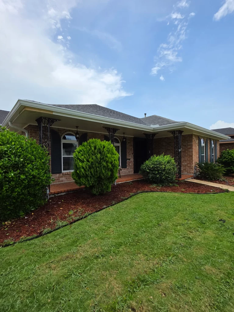 Newly installed seamless gutters protecting a brick home in Metairie, LA, showcasing Capital Improvement's gutter