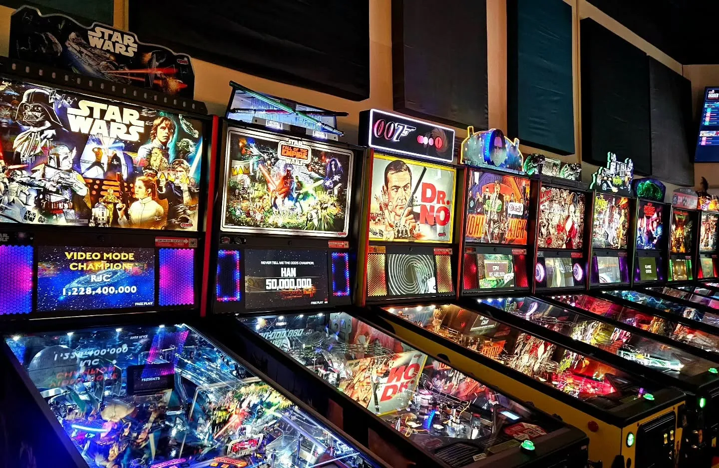 Radioactive Pinball Arcade, Augusta, GA: row of lit pinball machines inside an arcade, including Star Wars and James Bond Dr. No themed machines