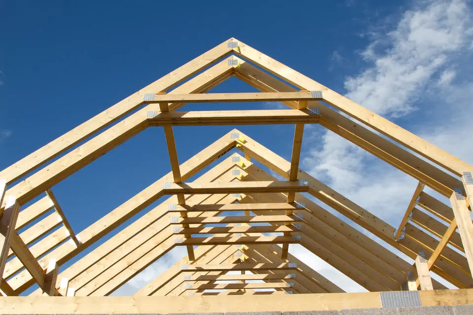 roof trusses-view of roof trusses installed during house construction with blue sky in the background